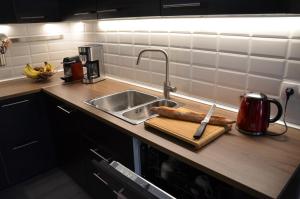 a kitchen counter with a sink and a cutting board at Bleautiful "Blanche" Charmant duplex tout confort in Fontainebleau +7 photos
