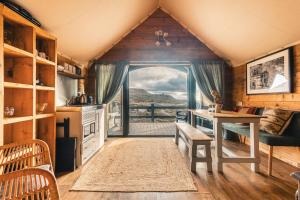 a kitchen with a table and a large window at Llechwedd Glamping in Blaenau-Ffestiniog