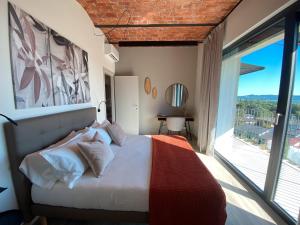 a bedroom with a bed and a large window at Beut Home Apartments in Gavirate