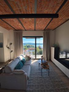 a living room with a couch and a large window at Beut Home Apartments in Gavirate