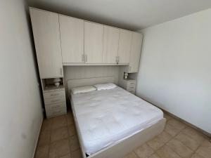 a small bedroom with a bed and white cabinets at BIJOU in Conca