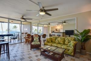 a living room with a couch and a table at Oceanfront Lahaina Condo with Balcony and Pool Access! in Kahana
