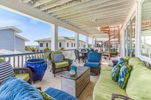 a porch with couches and chairs on a balcony at Tenth Street Retreat in Tybee Island