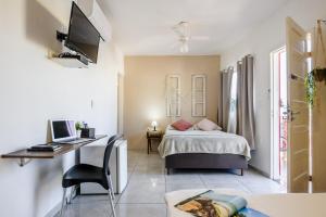 ヴィラ・ヴェーリャにあるHotel Prainhaのベッドとパソコン付きの机がある寝室