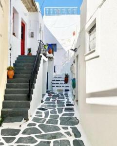 a narrow alley with stairs in a town at Cabarnus House in Parikia