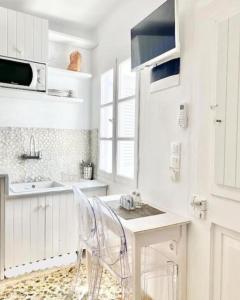 a white kitchen with a table and chairs in it at Cabarnus House in Parikia +36 photos
