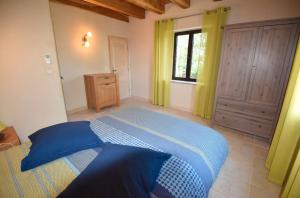 ein Schlafzimmer mit einem blauen Bett und einem Fenster in der Unterkunft Charmante Villa en Pierre - Piscine in Vézac