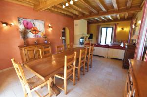 ein Esszimmer mit einem großen Holztisch und Stühlen in der Unterkunft Charmante Villa en Pierre - Piscine in Vézac