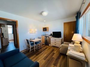 a living room with a couch and a table with a television at Mariner Inn And Suites in Kill Devil Hills