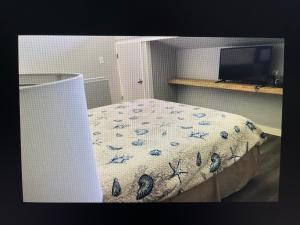 ein Schlafzimmer mit einem Bett mit Bettdecke und einem Fernseher in der Unterkunft Condo 326 in Cedar Key