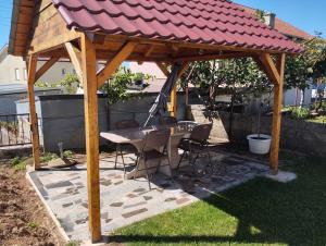 a wooden gazebo with a table and chairs under it at Apartman Centar comfort in Posušje