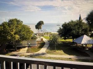 Blick auf ein Haus mit Zaun und das Meer in der Unterkunft Condo 326 in Cedar Key