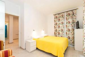a bedroom with a yellow bed and a curtain at Villa tranquilla immersa nel verde a 2 Km dal mare in Chiavari