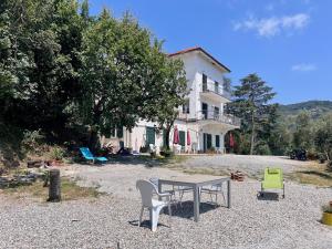 a table and chairs in front of a house at Villa tranquilla immersa nel verde a 2 Km dal mare in Chiavari