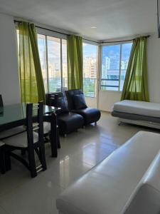 een woonkamer met een bank, een tafel en stoelen bij Apartamento con vista al laguito y al mar in Cartagena