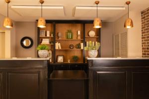 a bar with brown cabinets and pendant lights at Hôtel Le Fer à Cheval in Trouville-sur-Mer +58 photos