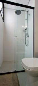 a bathroom with a glass shower with a toilet at Apartamento Novinho na Praia de Palmas em Gov Celso Ramos in Governador Celso Ramos
