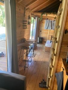 ein Zimmer mit einem Tisch und Stühlen in einem Blockhaus in der Unterkunft Le nid de l Eyrieux in Saint-Martin-de-Valamas