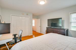 a bedroom with a bed and a desk and a television at Train to Boston! Cozy Apartment in Winchester in Woburn