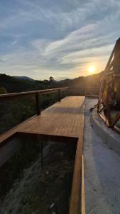 una terrazza in legno con tramonto sullo sfondo di Zaca Domos l Ouro Preto - MG a Mariana