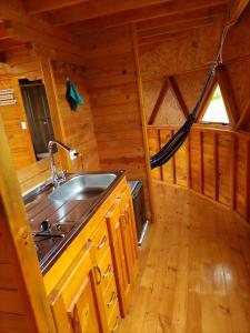 a kitchen with a sink in a log cabin at Colombia Mountain Tours Glamping in Choachí