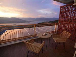 a balcony with chairs and a table with a view at The Mansion Resort And Spa in Panchgani
