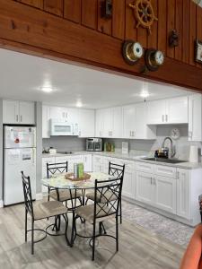 a kitchen with white cabinets and a table and chairs at Sunset Vista Condo 328 in Cedar Key