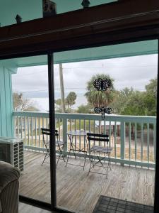 a screened in porch with a table and chairs at Sunset Vista Condo 328 in Cedar Key