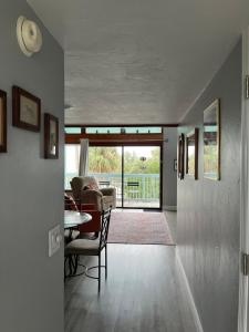a hallway with a living room with a table and chairs at Sunset Vista Condo 328 in Cedar Key