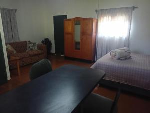een woonkamer met een tafel, een bed en een stoel bij Mooi Uitsig Droom in Beaufort West