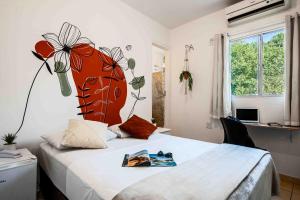 ヴィラ・ヴェーリャにあるHotel Prainhaの壁に花が飾られたベッドのある寝室