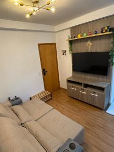 a living room with a bed and a flat screen tv at Recanto Augusta in Londrina