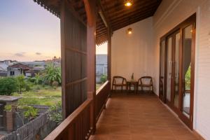 a porch of a house with a table and chairs at Kubu Daje Villa Canggu 2BR With Private Pool in Dalung