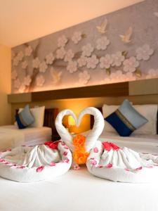 two swans shaped like hearts sitting on a bed at Chongkhao Resort- Phi Phi Island in Phi Phi Don