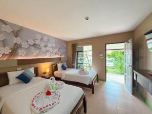 a bedroom with two beds and a room with two tables at Chongkhao Resort- Phi Phi Island in Phi Phi Don