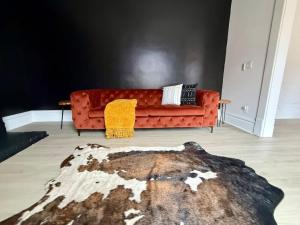an orange couch in a living room with a rug at Short North Convention King Bed Free Parking! in Columbus +42 photos