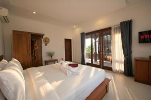 a bedroom with a large white bed with towels on it at Kubu Daje Villa Canggu 2BR With Private Pool in Dalung +36 photos