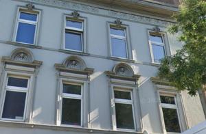 - un bâtiment blanc avec des fenêtres sur le côté dans l'établissement 5 Personen Apartment mit Badezimmer und Küche, à Niederdorla