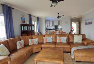 a living room with a brown couch and a table at 7 Vallen Lodge in Ballito