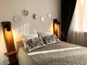 a bedroom with a bed with pillows and plates on the wall at Li Amber Apartment Carnikava in Carnikava