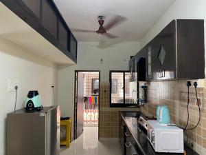 a kitchen with a refrigerator and a microwave at Sun & Sand Candolim Goa in Candolim