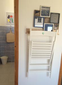 une échelle blanche dans une salle de bains avec des photos sur le mur dans l'établissement Primasrima Apartments, à Vodice