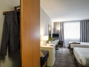 a hotel room with a bed and a desk at Novotel Glasgow Centre in Glasgow