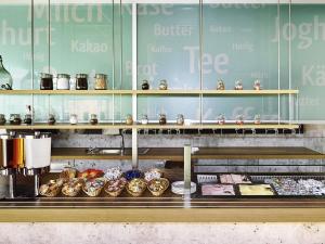 un comptoir de boulangerie avec des beignets et autres pâtisseries dans l'établissement ibis budget Zurich City West, à Zurich