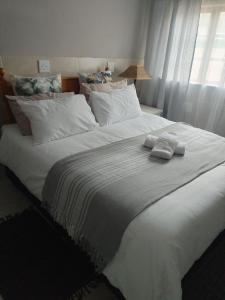 a large white bed with two towels on it at Le Caille, St Lucia Two bedroom unit in St Lucia