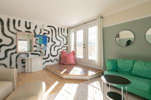 a living room with a green couch and a mirror at #Le80ies - Downtown Rooftop - Free shuttle to ski Mountain in Mont-Tremblant