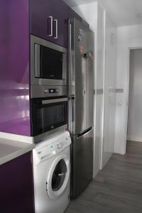a kitchen with a washing machine and a refrigerator at Grey House in Huelva