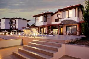 a house with stairs and chairs in front of it at Maisonette Allegro in Ormos Panagias