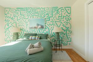 a bedroom with a green bed with a patterned wall at #Le80ies - Downtown Rooftop - Free shuttle to ski Mountain in Mont-Tremblant
