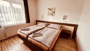 a bedroom with a bed with two towels on it at Penzion Ranch in Hořovice